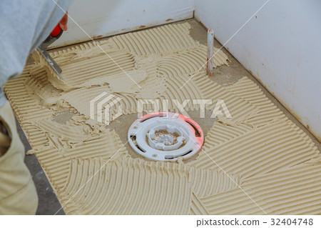 master puts on the floor adhesive for tiling master puts on the floor adhesive for tiling 32404748