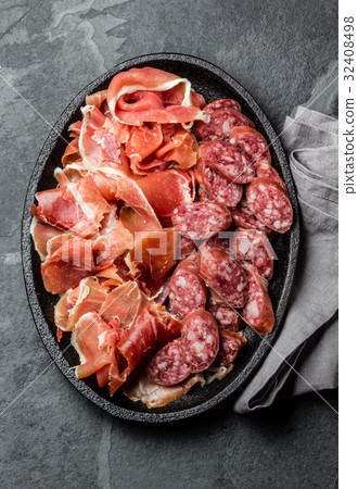 Spanish ham serrano and salami on slate, top view Spanish ham serrano and salami on slate, top view 32408498