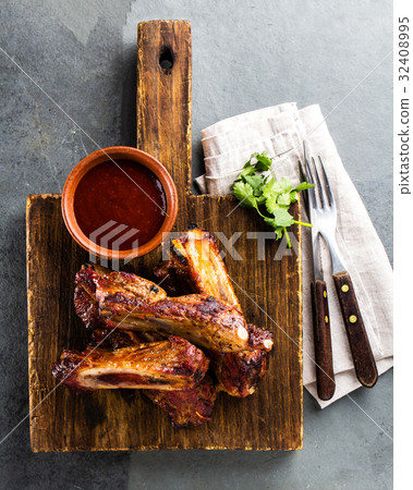 Pork ribs on cutting board with chili sauce Pork ribs on cutting board with chili sauce 32408995