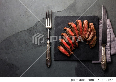 Medium rare beef steak on slate board, vintage Medium rare beef steak on slate board, vintage 32409462