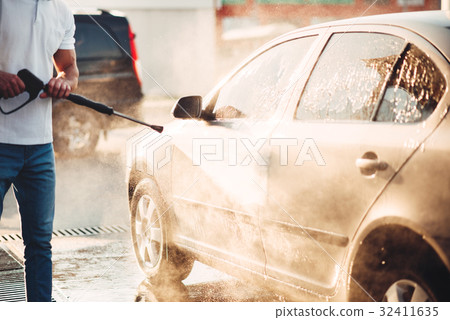 Male worker wash the car with high pressure washer 32411635