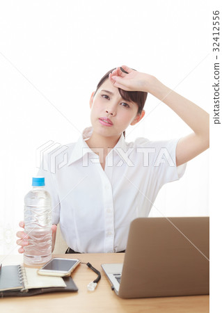 Hydration Supply A young woman in the office that puts his hands on the forehead by the hot weather 32412556