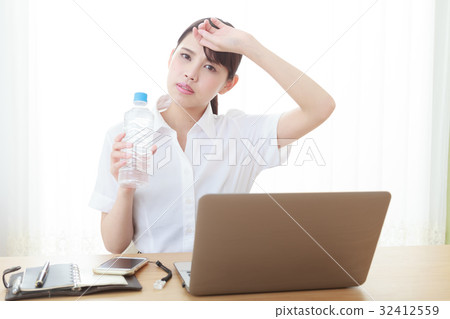 Hydration Supply A young woman in the office that puts his hands on the forehead by the hot weather 32412559
