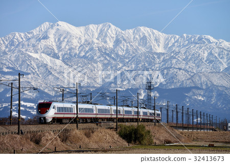 Nine cars of the 683 series 8000-series Hakutaka express train running with the Tateyama mountain range in the background 32413673