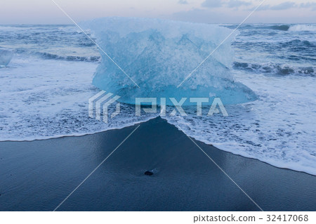 Ice breaking from glacier on black sand beach Ice breaking from glacier on black sand beach 32417068