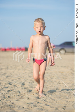 Cute baby boy walking on sandy beach near the sea Cute baby boy walking on sandy beach near the sea 32428121