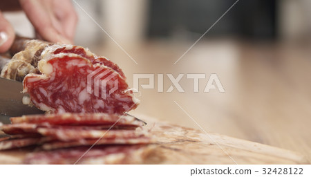 female teen hand slicing dried italian salami female teen hand slicing dried italian salami 32428122