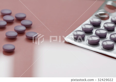 Close-up of purple pills in a pack on a pink Close-up of purple pills in a pack on a pink 32429022