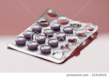 Close-up of purple pills in a pack on a pink Close-up of purple pills in a pack on a pink 32429026