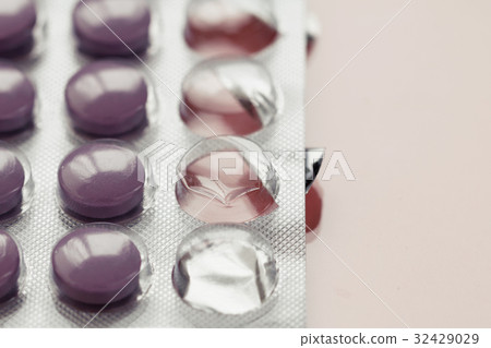 Close-up of purple pills in a pack on a pink Close-up of purple pills in a pack on a pink 32429029