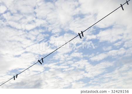 Blue clothesline over cloudy sky Blue clothesline over cloudy sky 32429156