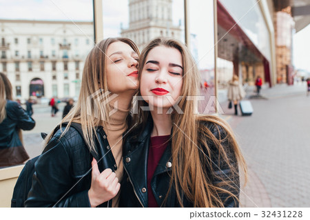 Two friends meeting in the street and hugging 32431228