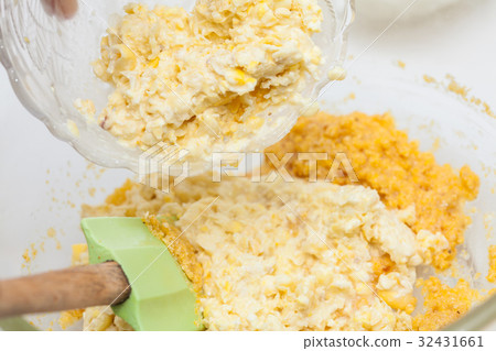 Adding shredded corn kernels to prepare arepa 32431661