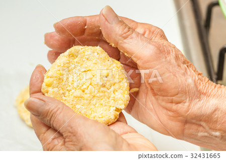 Flatten the dough balls to form the arepa shape 32431665
