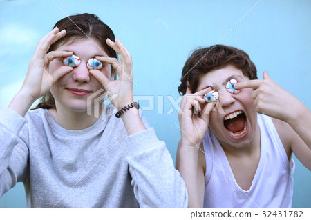 boy and girl with jujube marshmellow eyes smiling open mouth close up portrait 32431782