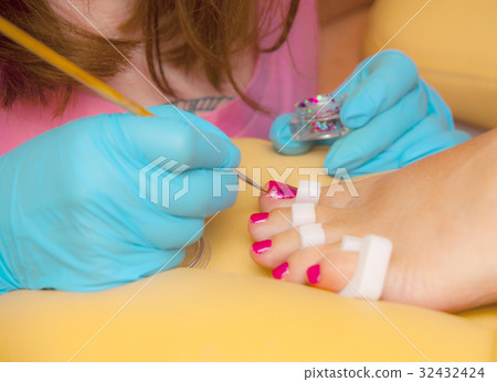 Master does a pedicure in a beauty salon. 32432424