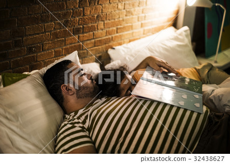 Father and daughter fall asleep during bedtime story 32438627