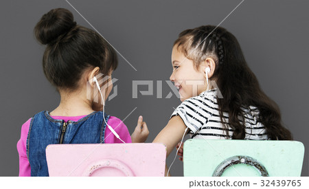 Rear view of two girls listening to music Rear view of two girls listening to music 32439765