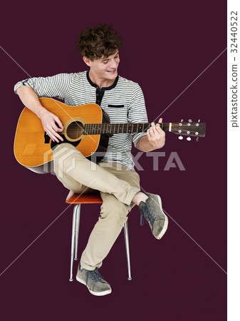 Man guitarist player sitting and playing guitar Man guitarist player sitting and playing guitar 32440522