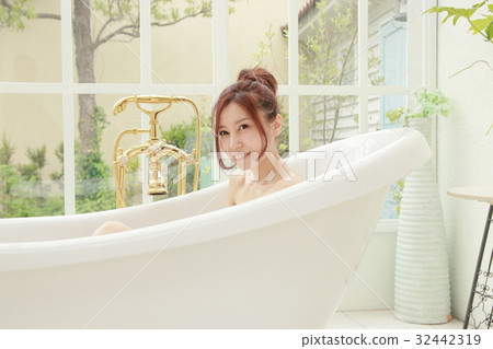 A woman immersed in a cat leg foot bathtub A woman immersed in a cat leg foot bathtub 32442319