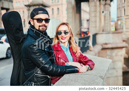 Beautiful couple in sunglasses on bridge in city  32445425