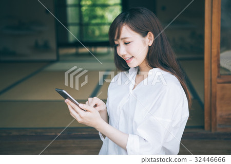 觀看在邊緣的一名婦女一個智能手機 觀看在邊緣的一名婦女一個智能手機 32446666