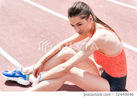 Happy girl relaxing after jogging on stadium Happy girl relaxing after jogging on stadium 32449046