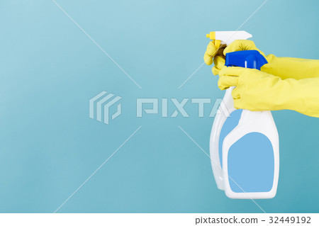 Hand in yellow glove holds  spray bottle of liqui 32449192