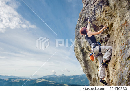 Female rock climber on steep overhanging rock cliff 32450280