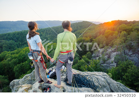 Couple of climbers resting and enjoying beautiful nature view Couple of climbers resting and enjoying beautiful nature view 32450310