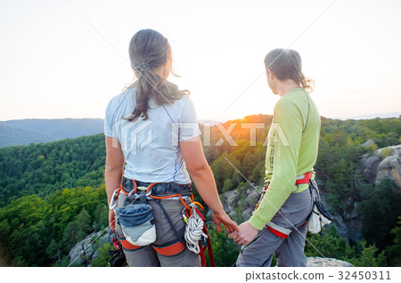 Couple of climbers resting and enjoying beautiful nature view Couple of climbers resting and enjoying beautiful nature view 32450311