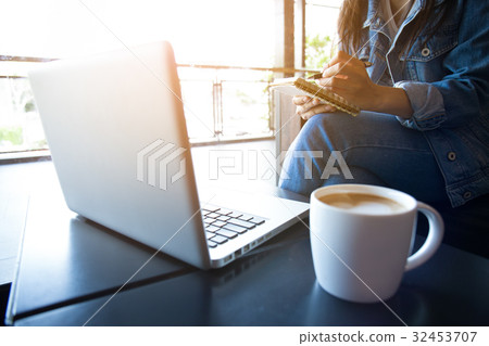woman using laptop and writing in notepad. 32453707