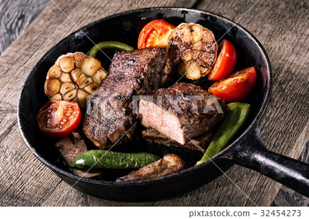 Juicy steak with vegetable garnish on an old 32454273