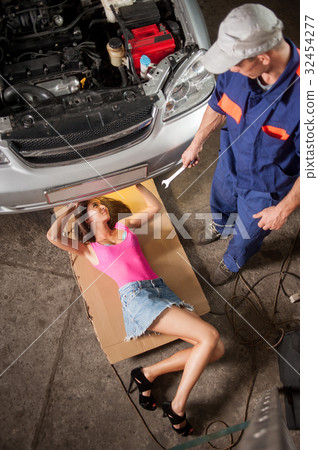 Sexy girl lying under car checking the engine 32454277