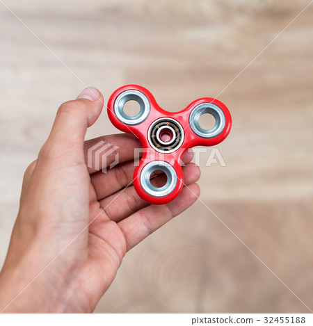 Fidget spinner. Red hand spinner, fidgeting hand 32455188