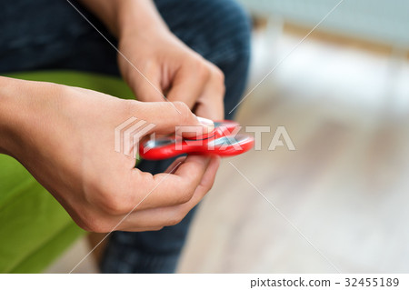 Fidget spinner. Red hand spinner, fidgeting hand 32455189