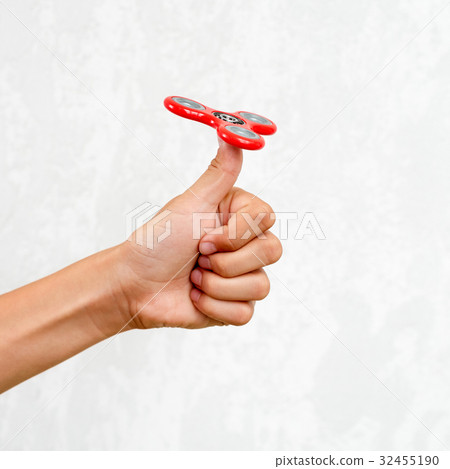 Fidget spinner. Red hand spinner, fidgeting hand 32455190