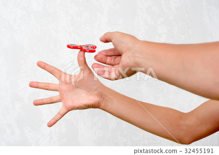 Fidget spinner. Red hand spinner, boys playing Fidget spinner. Red hand spinner, boys playing 32455191
