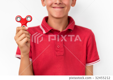 Red hand spinner. Boy playing a popular toy fidget 32455212