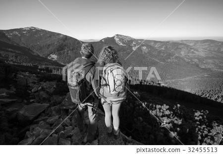 Hikers standing at the mountain peak on a sunny day 32455513
