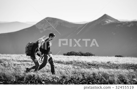 Couple hiking in the beautiful mountains on warm sunny day Couple hiking in the beautiful mountains on warm sunny day 32455519