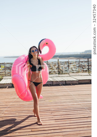 woman holding pink inflatable flamingo float 20s woman holding pink inflatable flamingo float 20s 32457340