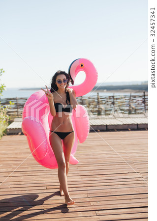 woman holding pink inflatable flamingo float 20s woman holding pink inflatable flamingo float 20s 32457341