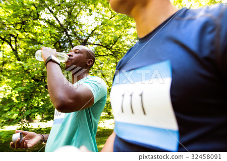 Two young athletes prepared for run, drinking Two young athletes prepared for run, drinking 32458091