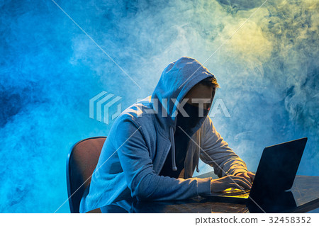 Hooded computer hacker stealing information with 32458352