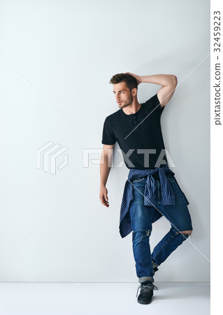 Full length portrait of handsome stylish man leaning at white wa Full length portrait of handsome stylish man leaning at white wa 32459223