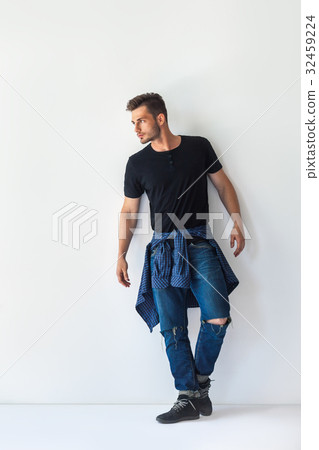 Full length portrait of handsome stylish man leaning at white wa Full length portrait of handsome stylish man leaning at white wa 32459224