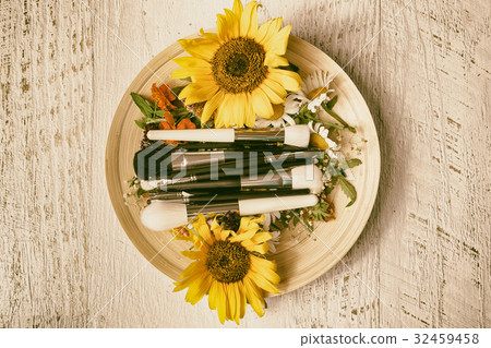 Make up brushes on plate next to wild flowers Make up brushes on plate next to wild flowers 32459458