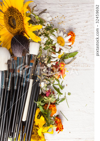 Make up brushes on a pile of wild flowers Make up brushes on a pile of wild flowers 32459692