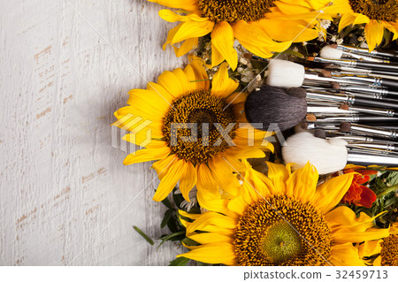 Make up brushes next to beautiful wild flowers 32459713